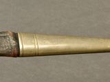 a small metal object with a long handle on a table