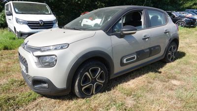 une voiture garée dans l'herbe, près d'autres voitures