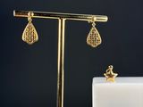 une paire de boucles d'oreilles en or posées sur un présentoir en forme d'étoile