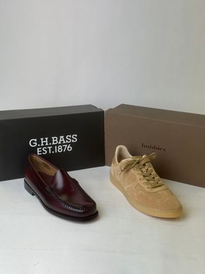 two pairs of men ' s shoes sitting next to a box of shoes