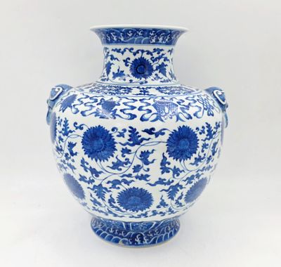 un vase bleu et blanc posé sur une surface blanche