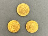 three indian gold coins, one of which is a head and one of which is a head