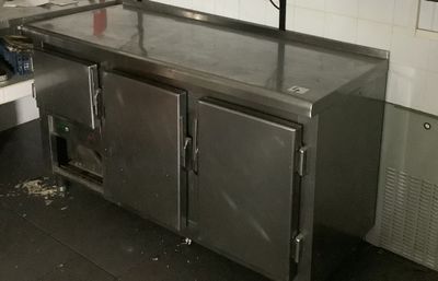 une grande cuisine en inox équipée d'un évier et d'un plan de travail