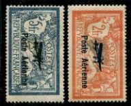 four different postages of different colors and sizes on a black background