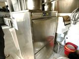a man that is standing in a kitchen with a pot
