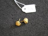 pair of gold plated stud earrings with a price tag on a black surface