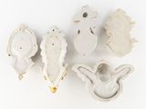 three white ceramic birds are sitting next to each other on a white surface
