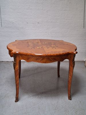 une petite table avec un plateau en bois sur un sol en ciment