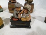 many figurines of children sitting on a bench