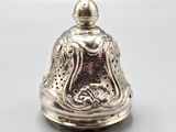 an image of a silver bell with a bird on top of it