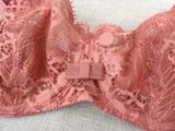 pink lace bralet with a bow tie on a white surface
