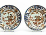 paire d'assiettes bleues et blanches ornées d'un motif représentant un homme et une femme dans un jardin