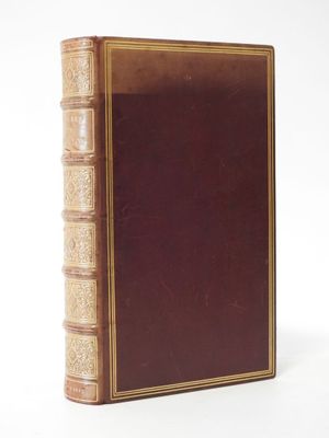 an old book sitting on top of a white table next to a white wall