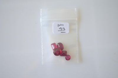 un petit sachet de pilules rouges posé sur une surface blanche