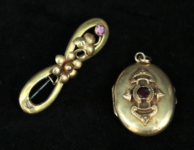 a gold locke with a pink stone in it and a gold locke with a pink stone in it