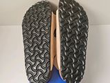 the soles of a pair of black shoes on top of a blue box