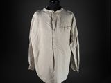 an old shirt on a mannequin stand against a black background