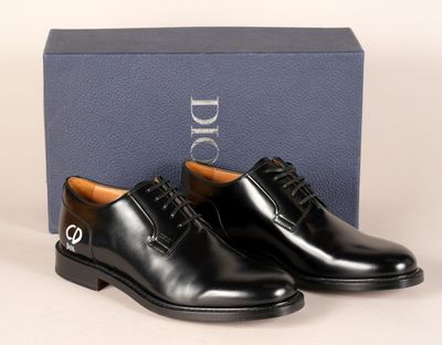 une paire de chaussures noires posée sur une boîte bleue
