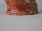 a brown vase sitting on a table with a white background