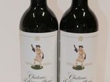 two bottles of red wine sitting next to each other on a table