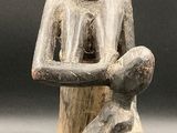 an image of a statue of a man sitting on a stool