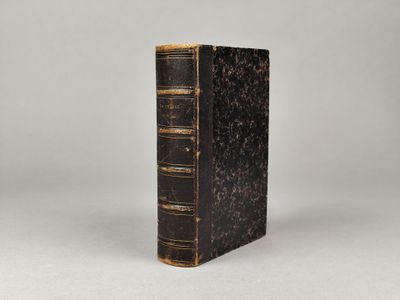un vieux livre posé sur une surface blanche