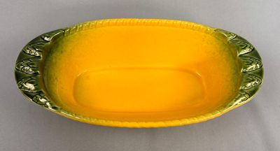 une image représentant un bol jaune posé sur une table blanche