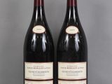 two bottles of wine sitting on top of a table next to each other