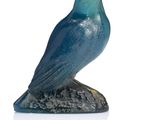 statue of a blue bird sitting on a rock on a white surface