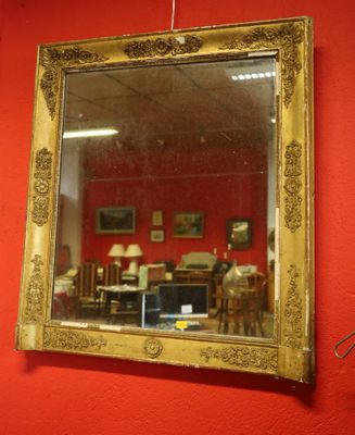 a mirror hanging on a red wall in a room