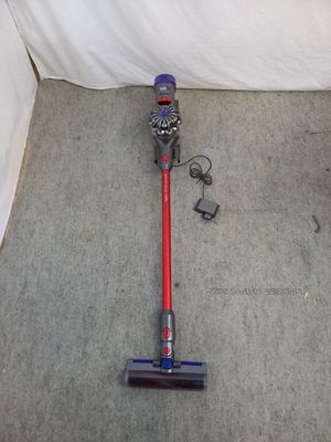 un aspirateur posé par terre à côté d'un lit