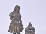 a small statue of a girl with a pot on a plate