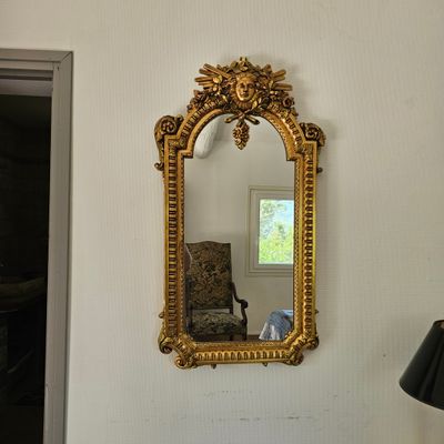 un miroir accroché au mur au-dessus d'une chaise
