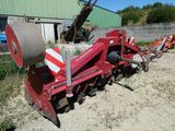 une machine rouge qui est à l'arrêt dans la poussière