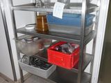 a metal shelving with many items on it in the kitchen