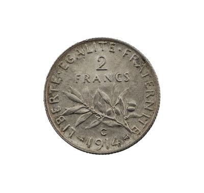 une vieille pièce de monnaie sur laquelle figure une branche, sur fond blanc