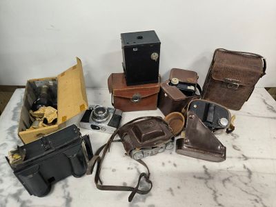 many different types of cameras on a marble table