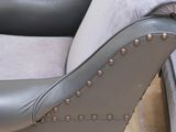 a grey leather chair with a gray pillow on it