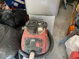 a pile of trash in a garage next to a refrigerator