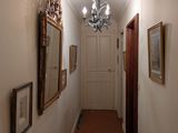a long hallway with a chandelier and pictures on the wall