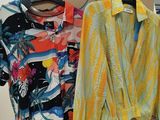 two shirts hanging on a clothes rack in a store
