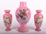 trois vases roses posés les uns à côté des autres sur une surface blanche