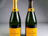 two bottles of champagne sitting next to each other on a table