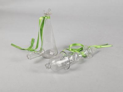 two empty glass vases with green ribbon on a white background