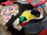 a pile of clothes in a suitcase on the floor