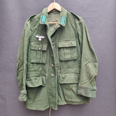 a green military jacket with a white bird on it