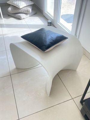 un banc blanc sur lequel est posé un coussin bleu
