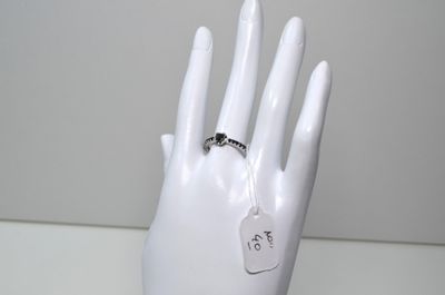une main de mannequin blanche avec une bague au doigt