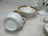 a white bowl and a bowl with a gold rim on a table