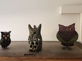 trois figurines de chouettes posées sur une table en bois